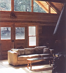 A vaulted ceiling and triangular window make the living room open, airy, and well-lit.
